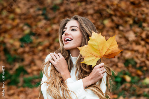 Happy autumn woman having fun with leaves outdoor in park. photo