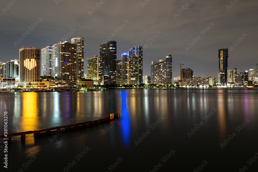 Naklejka premium Miami sunset panorama with colorful illuminated business and residential buildings and bridge on Biscayne Bay. Miami skyline on Biscayne Bay, city night backgrounds.