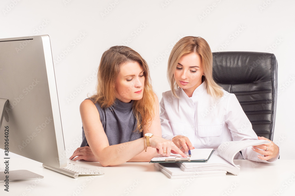 Two girls check documents. Women at the Desk look through documents. Auditor check. Two serious women at work. Office work. Two girls check documents. Women at the Desk look through documents. Auditor check. Two serious women at work. Office work.