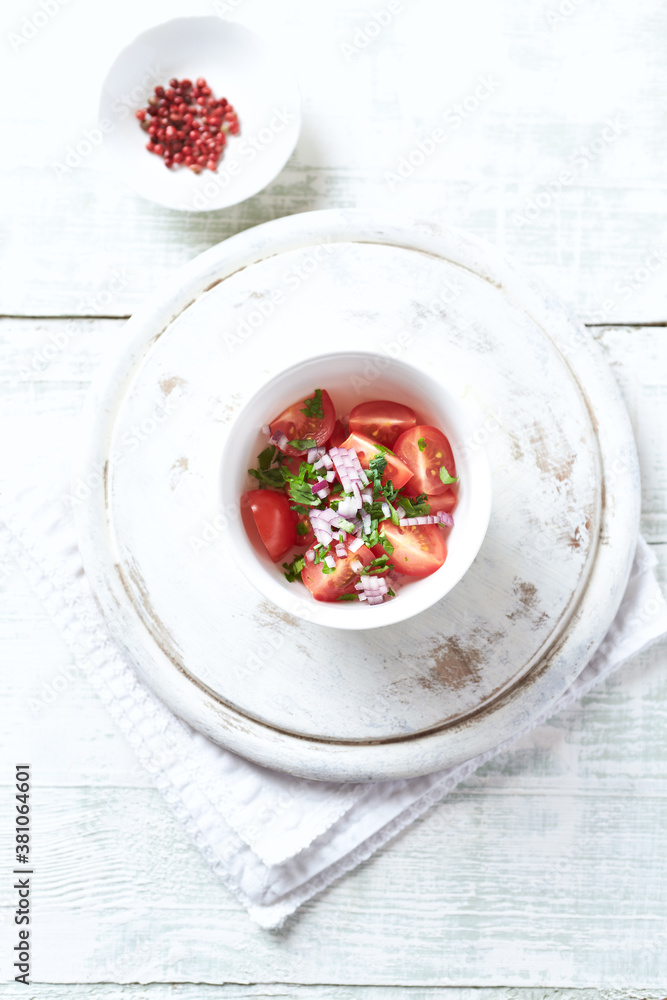 Simple salad with cherry tomatoes, red onion and fresh herbs. Bright wooden background. Top view. Simple salad with cherry tomatoes, red onion and fresh herbs. Bright wooden background. Top view.