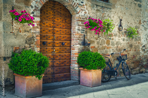 Photography Wooden door with flowery entrance and retro bicycle, Pienza, Tuscany