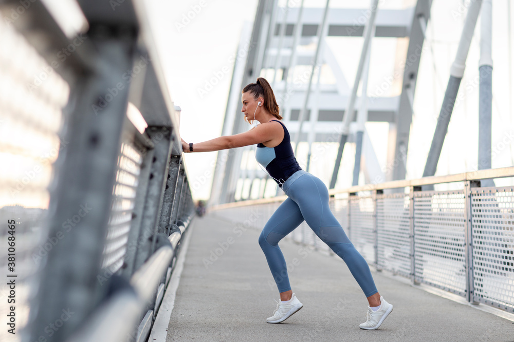 Long hair fit woman stretching outside and exercise on the bridge