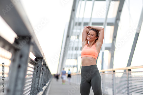 Long hair fit woman stretching outside and exercise on the bridge