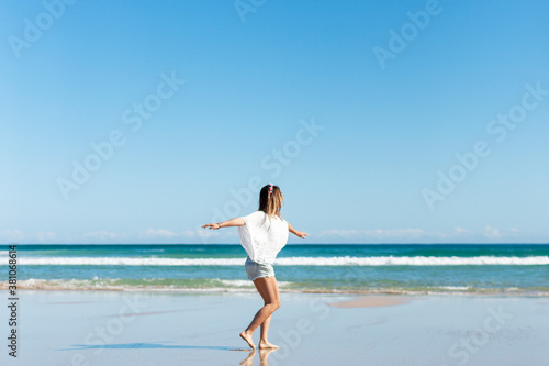 Young woman spinning on the beach