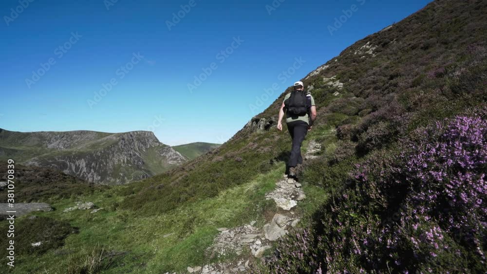 A man climbing a mountain in Wales towards Y Garn, Snowdonia A man climbing a mountain in Wales towards Y Garn, Snowdonia