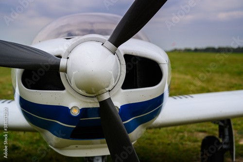small single-engine civil airplane on a green grass of a countryside airdrome