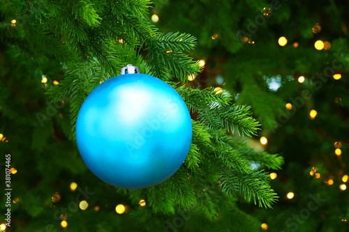 Blue christmas tree ball toy on christmas tree, space for text. Gifts and congratulations holidays concept, xmas