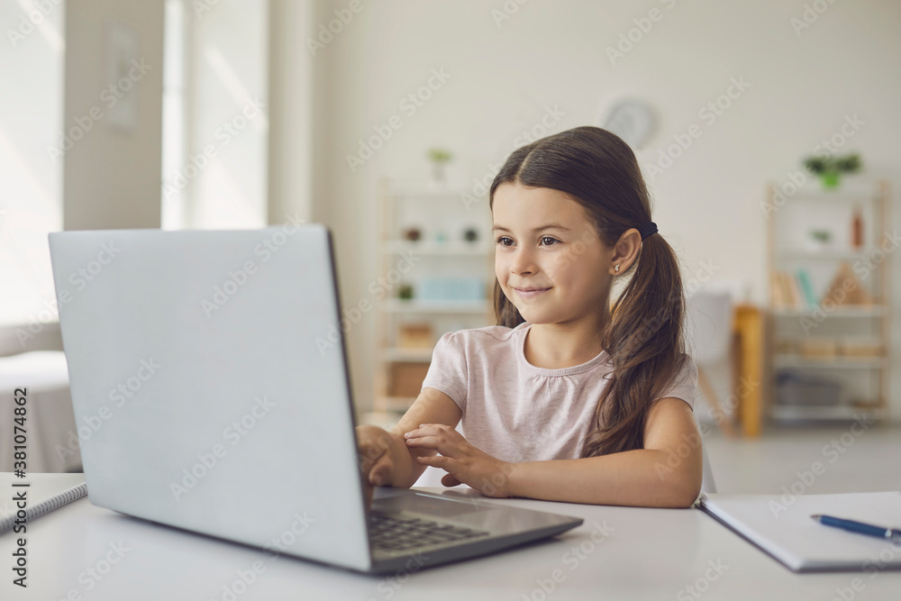 Smiling girl learning online at laptop from home Smiling girl learning online at laptop from home