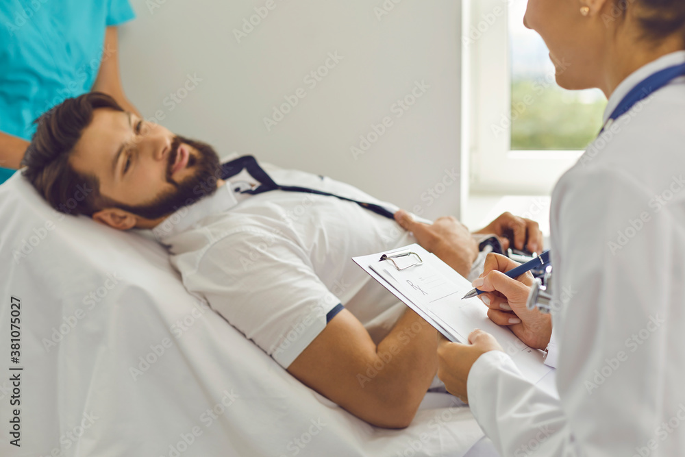 Young female doctor fills out a medical card with a hospitalized patient in a hospital ward. Young female doctor fills out a medical card with a hospitalized patient in a hospital ward.