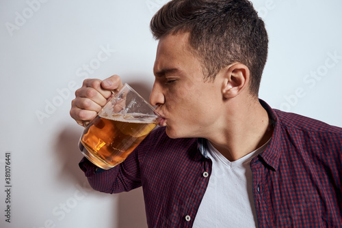 Cheerful man with mug of beer alcohol emotions light background