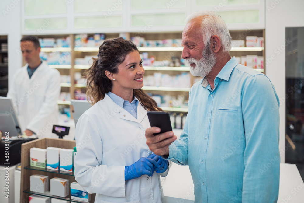 Obraz premium Professional pharmacist working with customers in modern drugstore.