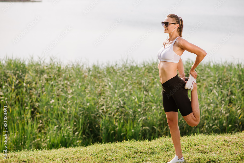 Young slim fit woman doing sport exercise outdoors in the park at the sunny day Young slim fit woman doing sport exercise outdoors in the park at the sunny day