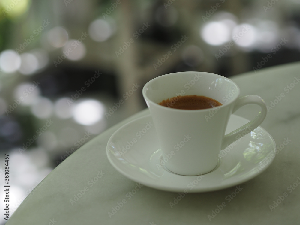 Espresso hot coffee in a white cup placed on marble table