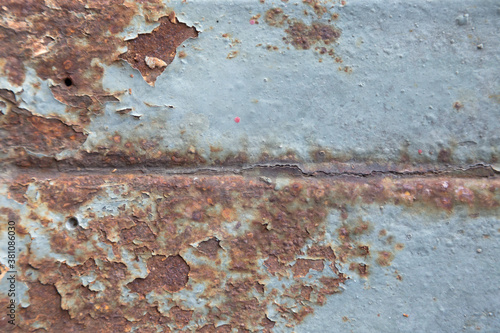 Rust has appeared on the blue painted metal wall.