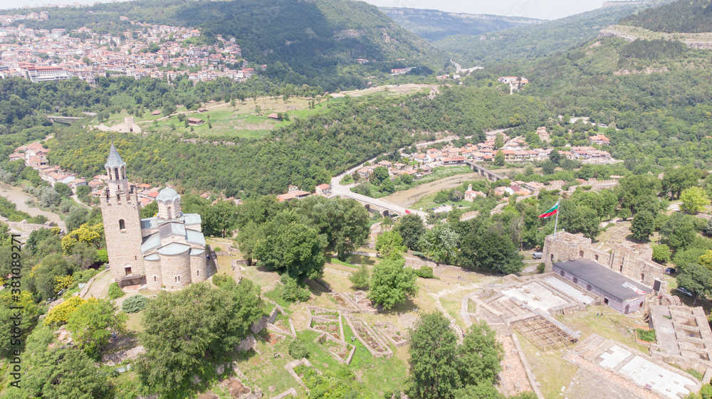Old Balkan fortress on Bulgaria, world heritage in Veliko Tarnovo. Historical structure medieval castle on a hill. Drone aerial view of sightseeing monument landmark. Cultural Stronghold