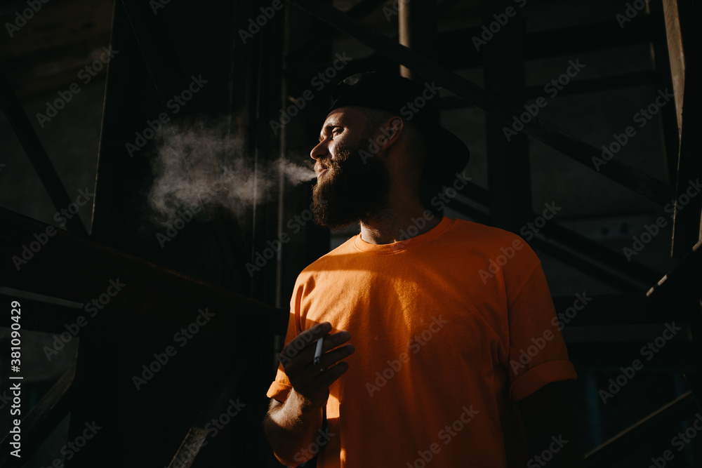 Portrait of brutal hipster man with cigarette. Bearded man smoking. Tobacco.