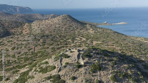 Aerial drone view of a dry, yellow landscape along the Greek coastline in Summer (Kolokytha, Elounda, Crete) photo