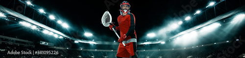 Lacrosse Player, athlete sportsman in red helmet on stadium background with lights. Sport and motivation wallpaper. Wide banner. photo