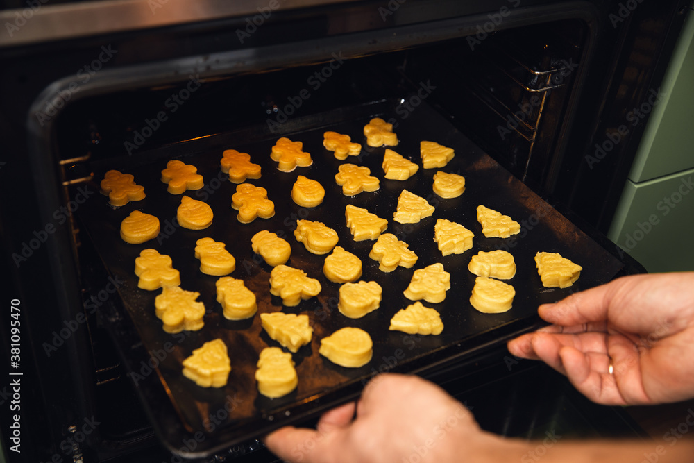 Hot sweet cookies in the oven. Man hold tray Hot sweet cookies in the oven. Man hold tray