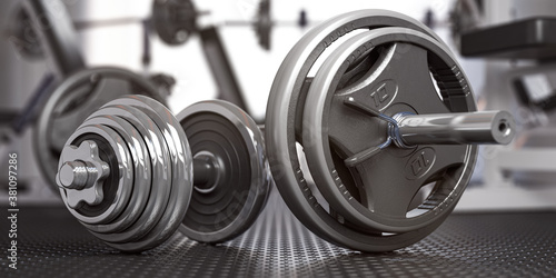 Dumbbell and barbell on the floor of gym. Close up fItness equipment. Sport, fitness and bodybuilding concept background