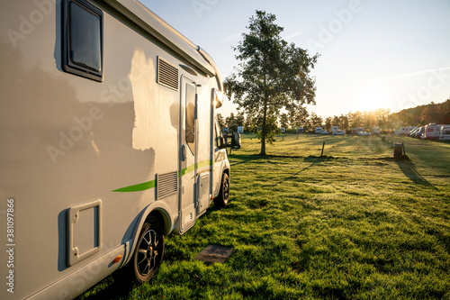 Fotografija motorhome in detail before rising sun with morning dew against the light