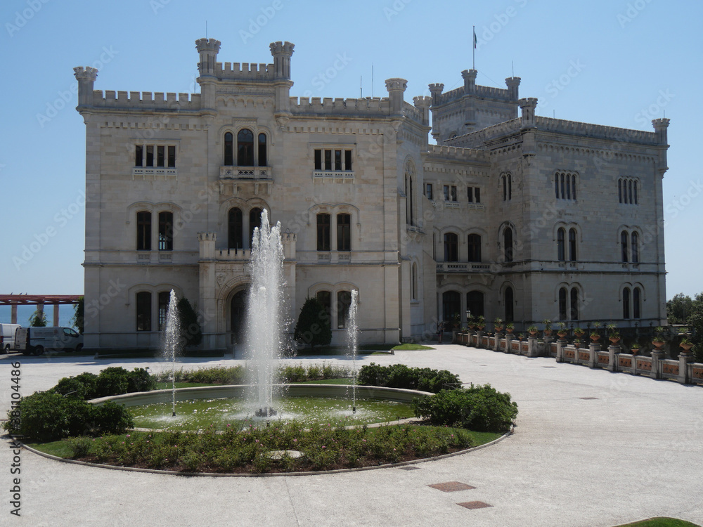 Miramare – Park and Fountain in front of the white Castle facade with the sea in the background