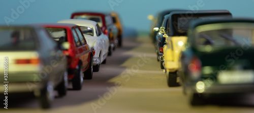 Fototapeta Naklejka Na Ścianę i Meble -  Looking through two rows of toy cars, symbol for start traffic and traffic jam, focus on one car