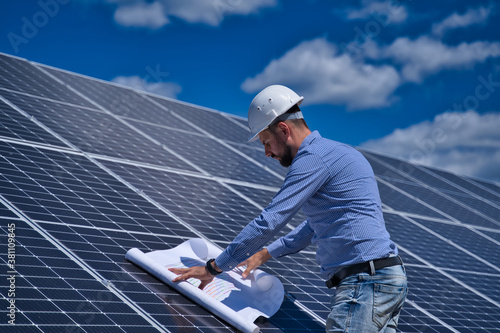 The engineer is checking the project of the solar station.