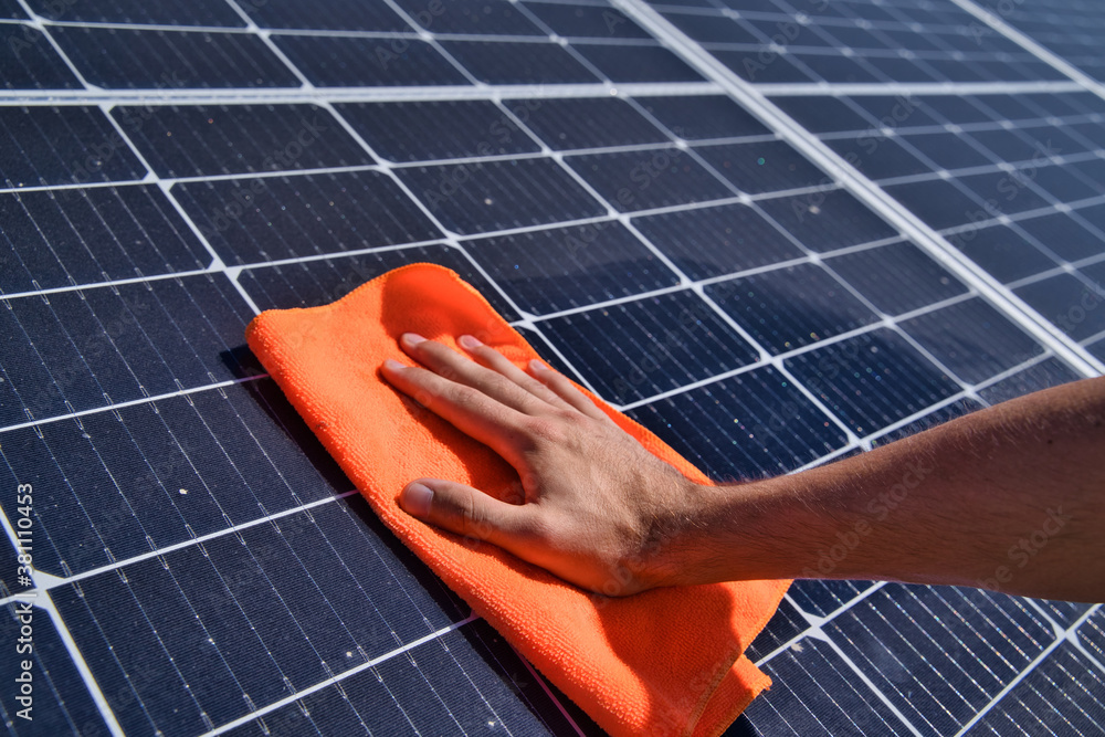 Cleaning solar panels from dirt. Hand washes solar panels. Stock Photo