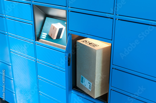 Photo Close up Of Light Blue Self-Service Post Terminal Machine With Touchscreen Monitor and Open Locker With Parcel Inside