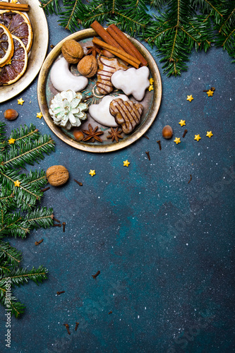 Beautiful Christmas background with decorations. Christmas cookies witch chocolate, gingerbread cookies, nuts and fir twigs on dark background. Copy space for your text