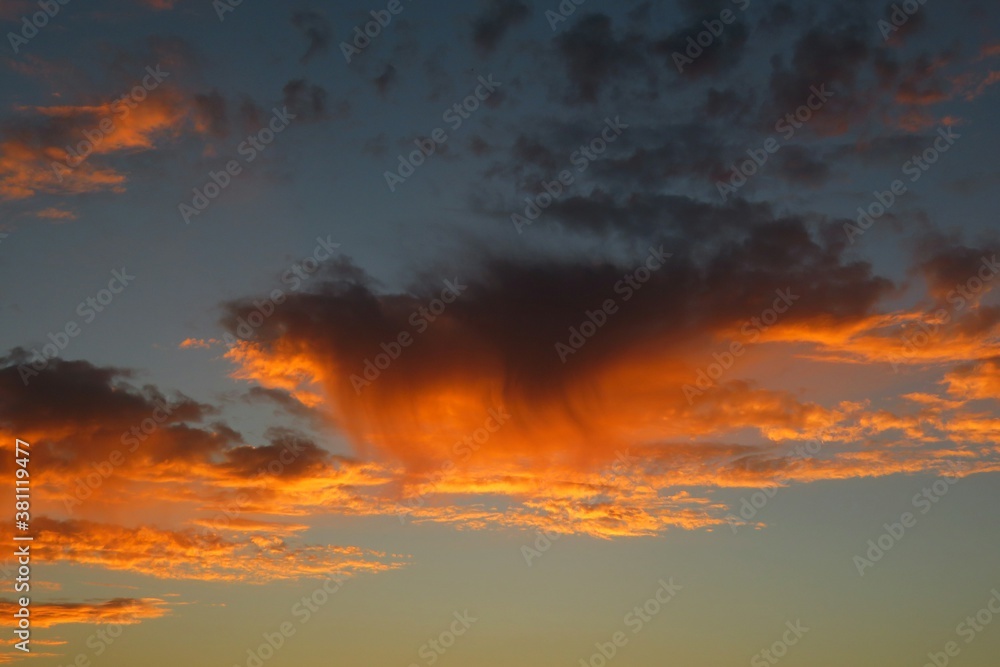 Naklejka premium Beautiful orange flame shape clouds in the sky at sunset, natural background