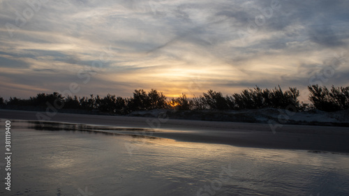 Pôr do sol na praia Village Dunas em Balneário Gaivota, Santa Catarina, Brasil. Capturado durante uma viagem de fim de semana pela praia. Núvens em formato de x. © studioneeby