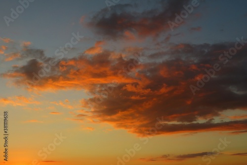 Beautiful fiery orange clouds in the sky at sunset, natural background © natalya2015