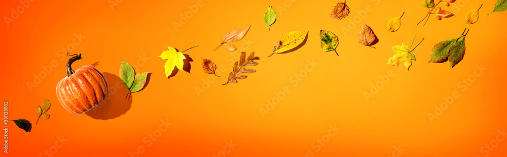 Naklejka premium Autumn pumpkin with colorful leaves overhead view - flat lay