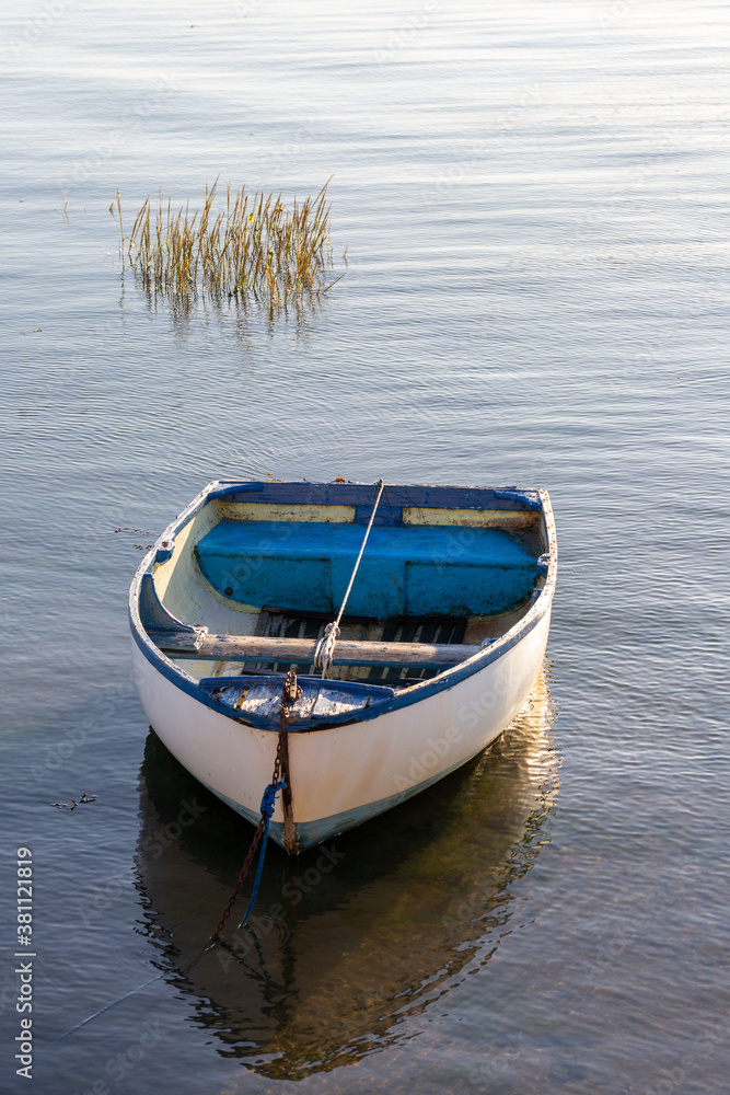 An old wooden boat moored in a calm marina