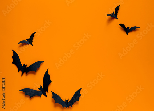 Bats on orange background . Halloween party greeting card mockup with copy space. Flat lay, top view.