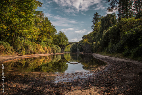 Ancient stone bridge in water reflection