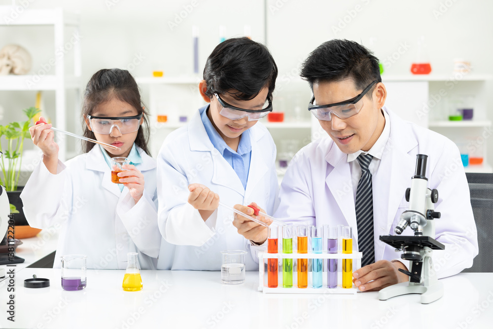 science teacher doing or testing a chemical experiment with child students in laboratory classroom science teacher doing or testing a chemical experiment with child students in laboratory classroom