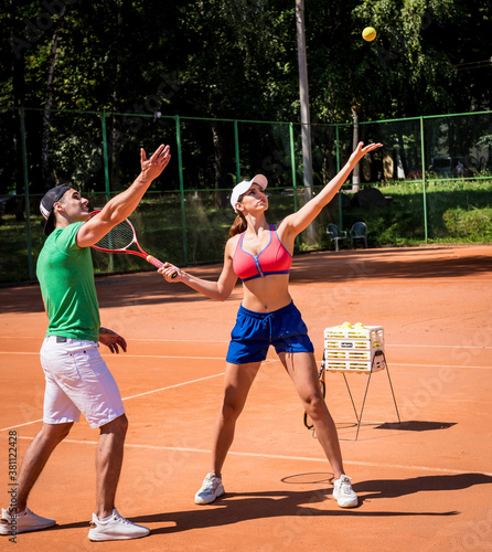 Young athletic woman playing tennis with her coach. © romaset