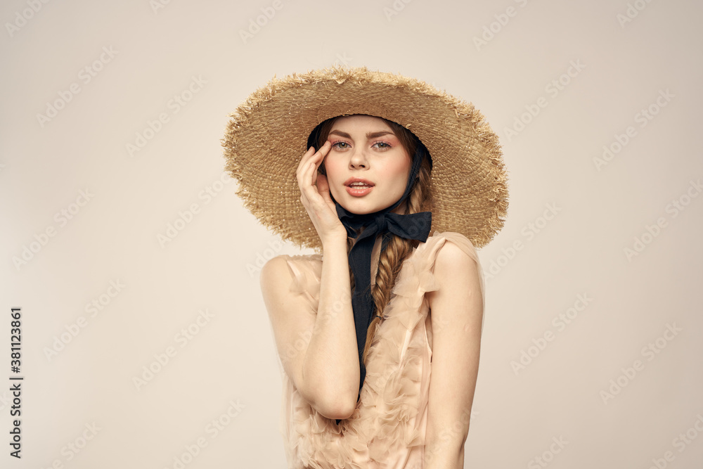Romantic woman in a hat and dress on a light background gestures with her hands portrait fun emotions cropped view Romantic woman in a hat and dress on a light background gestures with her hands portrait fun emotions cropped view