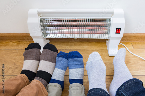 Εκτύπωση καμβά Young family warms his frozen legs near a heating radiator