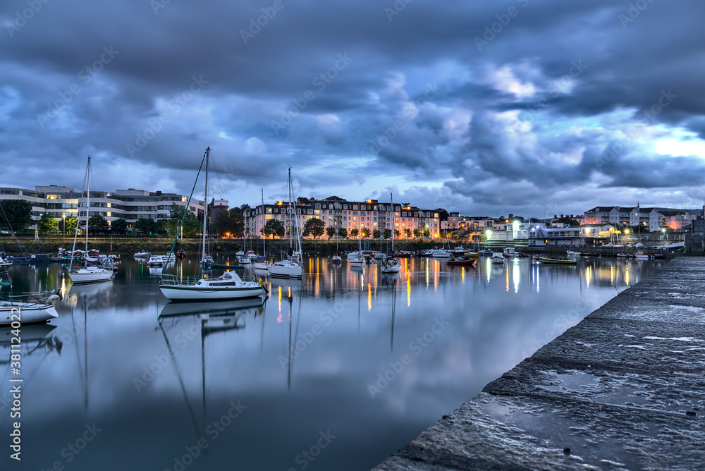 Dun Laoghaire harbor during the blue hour. West Pier. Evening shot of famous harbor in Dublin, Ireland