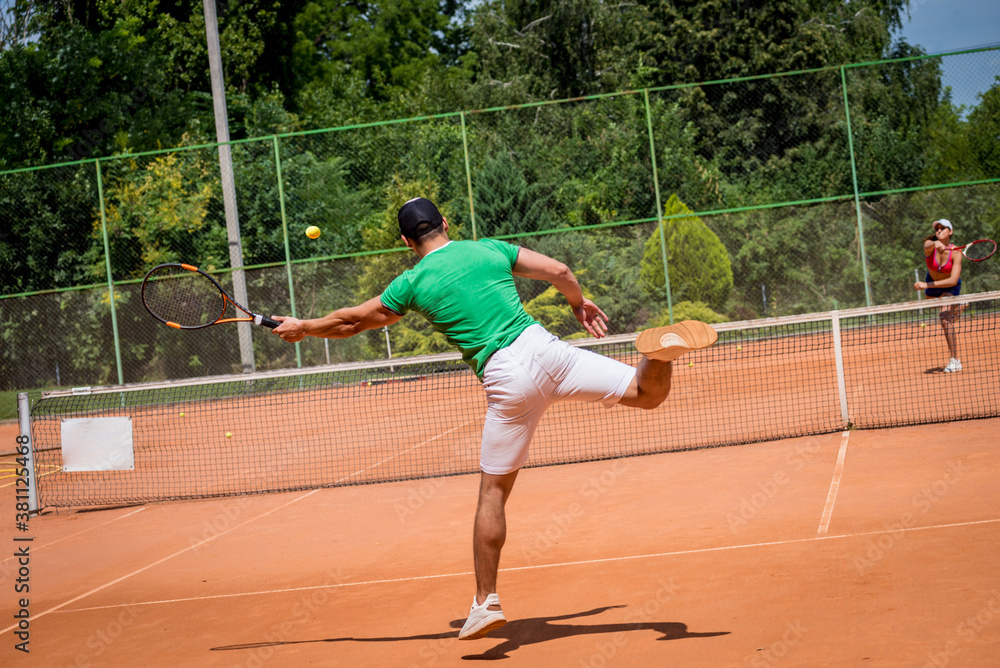 Young athletic couple playing tennis on the court. Young athletic couple playing tennis on the court.