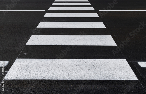 Front view of the pedestrian crossing, asphalt road, white stripes on a dark gray background, zebra stripes, perspective views, black and white, high temperature resistant draining asphalt.