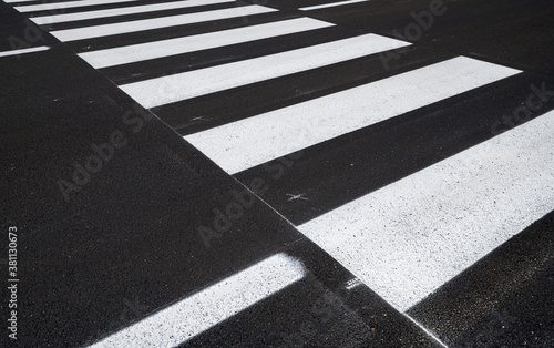 Side view of the pedestrian crossing, asphalt road, white stripes on a dark gray background, zebra stripes, perspective views, black and white, high temperature resistant draining asphalt.