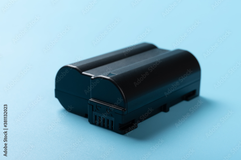 dark grey battery for digital camera on a blue background dark grey battery for digital camera on a blue background