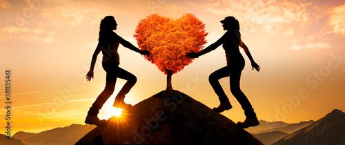 Zwei weibliche Silhouetten mit einem Herzbaum auf einem Gipfel
