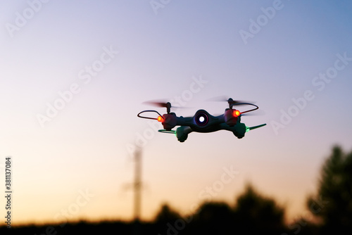 Fototapeta Naklejka Na Ścianę i Meble -  Toy drone quad copter against sunset sky