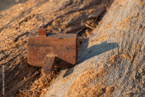 A small vintage planer rests on a stick and the sunlight blurs.